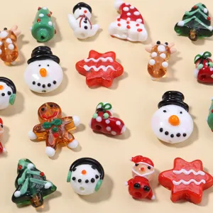Close-up detail of colorful Christmas glass lampwork beads featuring cute snowman designs.