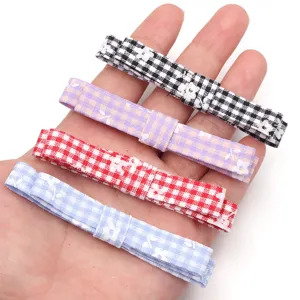 Detail view of colorful plaid fabric bows with small floral print, ideal for craft and DIY.