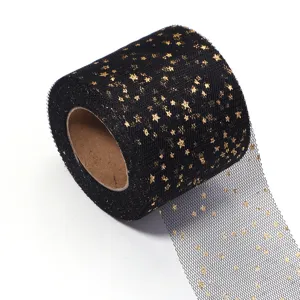 Detail view of black tulle mesh fabric roll with gold foil stars for DIY craft and party decor.