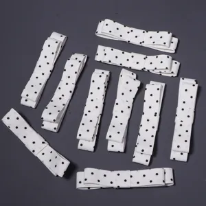 Vista detallada de accesorios de lazo con lunares blancos, ideales para manualidades y horquillas.