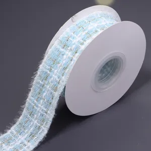 Close-up detail of light blue tweed ribbon with gold threads for DIY gift wrapping crafts.