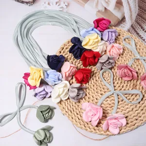 Close-up van kleurrijke satijnen roos stoffen bloemen en linten voor DIY haaraccessoires.
