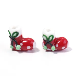 Close-up detail of red and white polka dot Christmas boot glass lampwork beads accessories.