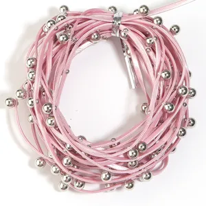 Close up detail view of pink leather cord strap with metallic silver bead ends for jewelry making.