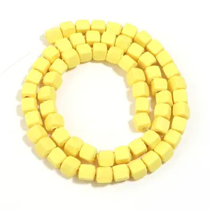 Primo piano dettaglio perla cubo giallo per creazione gioielli DIY accessorio distanziatore.