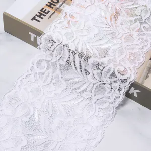 Close-up of white elastic lace trim fabric detail, perfect for sewing and DIY clothing crafts.