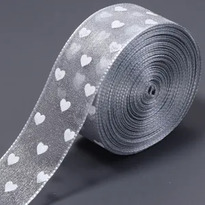 Nastro in organza trasparente argento con stampa di cuori bianchi per decorazioni.