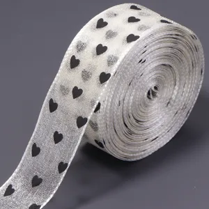 Rotolo di nastro in organza trasparente con cuori neri stampati, ideale per fiocchi DIY e regali.