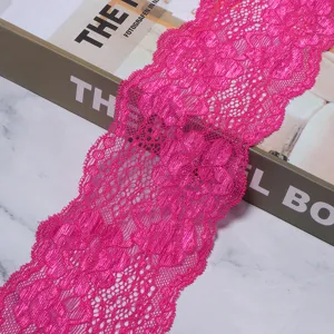 Bright pink lace trim detail shot, elastic floral webbing for DIY crafts and garment sewing.