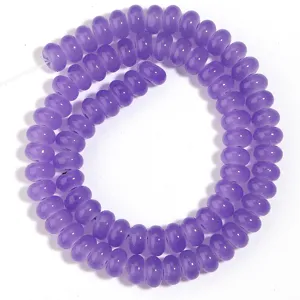 Primer plano de abalorios de ábaco de vidrio morado, superficie lisa, ideal para joyería DIY.
