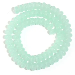 Abalorios de abaco de vidrio verde claro en primer plano, ideales para joyería DIY y pulseras.