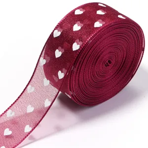 Primo piano dettagliato del nastro in organza trasparente bordeaux con motivo a cuori.