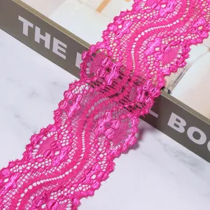Nahaufnahme von pinker Polyester-Spitzenborte, detailliertes Blumenmuster zum Nähen und Basteln.