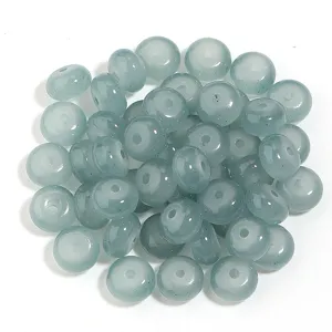 Vista detallada de cuentas de ábaco de vidrio cian pálido, ideales para joyería y manualidades DIY.