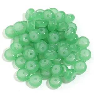 Primer plano detallado de cuentas de abaco de vidrio verde, ideales para joyeria artesanal.
