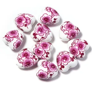 Perles de coeur en céramique avec motif floral rose, idéal pour des bijoux faits main DIY.