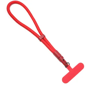 Détail de lanière de téléphone rouge avec dragonne tressée et languette sécurisée.