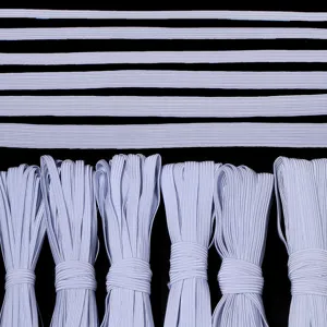 Vista detallada de bandas elásticas planas blancas y rollos, perfectas para coser y cinturillas.