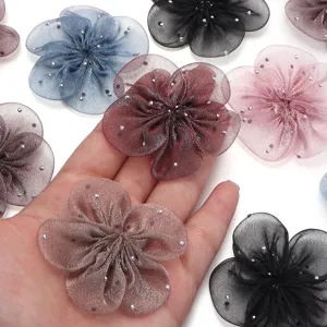 Nahaufnahme von transparenten Mesh Fünf-Blütenblatt Strass Blumen DIY Zubehör in bunten Farben.