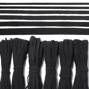 Vista detallada de bandas elásticas negras, con tiras planas y rollos atados para coser.