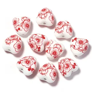 Détail de perles de cœur en céramique rouge et blanche, idéal pour les bracelets DIY faits main.