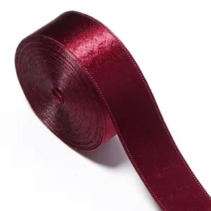 Close-up detail of dark red shiny ribbon roll, premium glitter fabric trim for crafts.