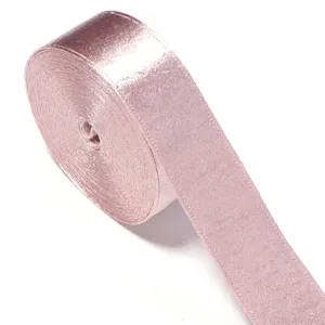 Close-up detail of a rolled pink shiny velvet ribbon for sewing and gift wrapping.