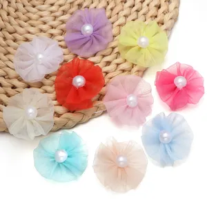 Nahaufnahme von bunten Netzstoff-Blumen DIY-Accessoires mit Perlenmitten für Haarklammern.