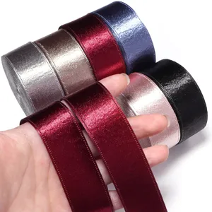 Closeup shot of colorful velvet ribbon rolls and sparkly fabric trims for gift wrapping details.