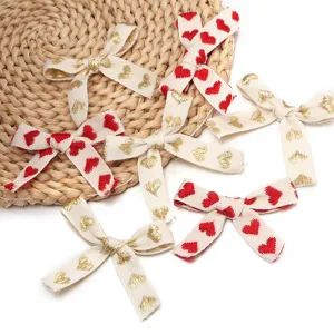 Fiocchi in nastro di cotone ricamato con cuori rossi e dorati per confezioni regalo.