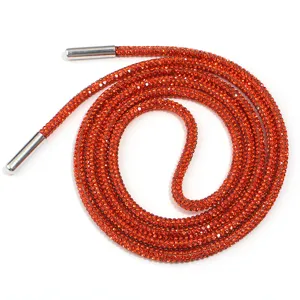 Gros plan du cordon de serrage en strass orange vif avec des embouts métalliques argentés.