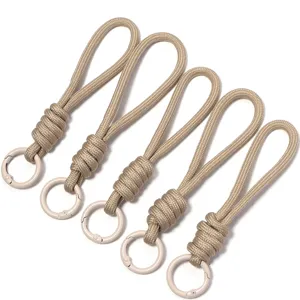 Detailed view of handmade khaki paracord lanyard straps with metal rings for DIY crafts.