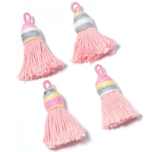 Close-up detail of mini gradient pink cotton tassels with shiny silk for DIY craft accessories.