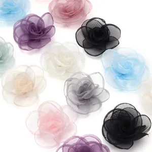Nahaufnahme bunter transparenter Mesh-Kamelien-Blumen-Accessoires fuer DIY und Haarspangen.