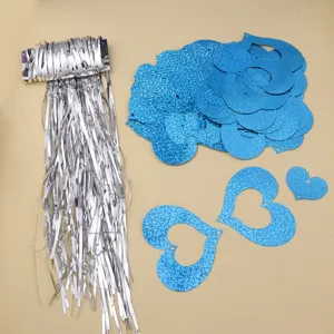 Detail view of blue glitter heart pendants and silver tinsel fringe curtain for party decor.