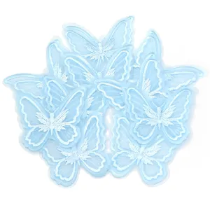 Close-up detail shot of light blue double-layer 3D lace butterfly applique embroidery.
