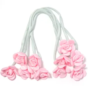 Roze stoffen roos lint detail met delicate knoppen en zachte bandjes voor kleding.