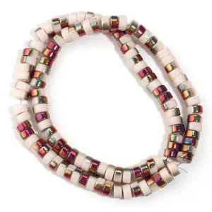 Detailed shot of electroplated wheel spacer beads, colorful metallic luster on pinkish base.