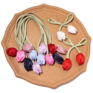 Vue détaillée de charms tulipes en ruban satin coloré avec strass pour loisirs et déco.