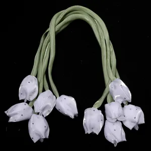 Vue détaillée de bourgeons de tulipes en tissu artificiel avec clous et tiges de ruban.
