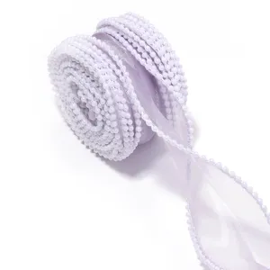 Close-up detail of light purple organza ribbon with white pearl edge for gift wrapping crafts.