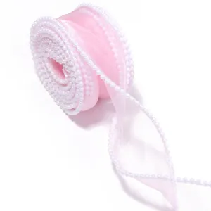Close-up detail of pink organza ribbon with delicate pearl beaded edge for craft and decor.