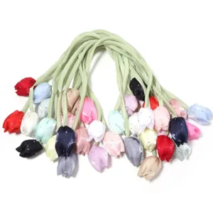Gros plan de détails d'accessoires de cheveux en tissu tulipe colorés avec strass et rubans.