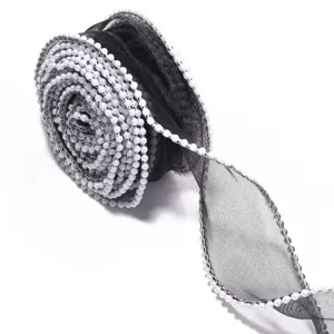 Black organza ribbon with white pearls detail shot for gift packaging and craft decoration.