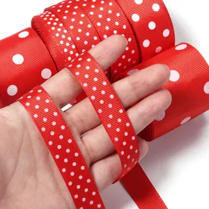 Primo piano dettagliato di nastro in gros-grain rosso con pois bianchi per artigianato e decoro.