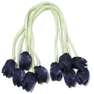 Gros plan détaillé de boutons de tulipes en satin bleu marine avec strass et rubans verts.