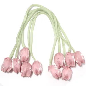 Bourgeons de tulipes en satin rose avec tiges de ruban vert et strass brillants.