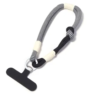 Nahaufnahme des schwarz-weißen gewebten Handgelenksbands mit Handylasche und Metallring.