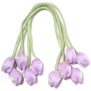 Vue détaillée de boutons de fleurs de tulipe en tissu violet avec strass et tiges vertes.