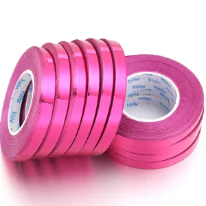 Close-up detail of shiny pink metallic laser balloon ribbons for gift wrapping and party decor.